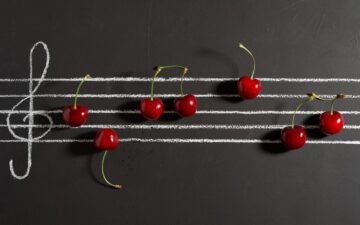 black board with sheet music and cherries.