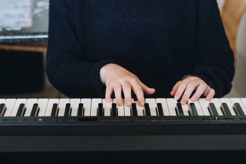 Person in black shirt playing piano.