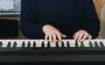 Person in black shirt playing piano.