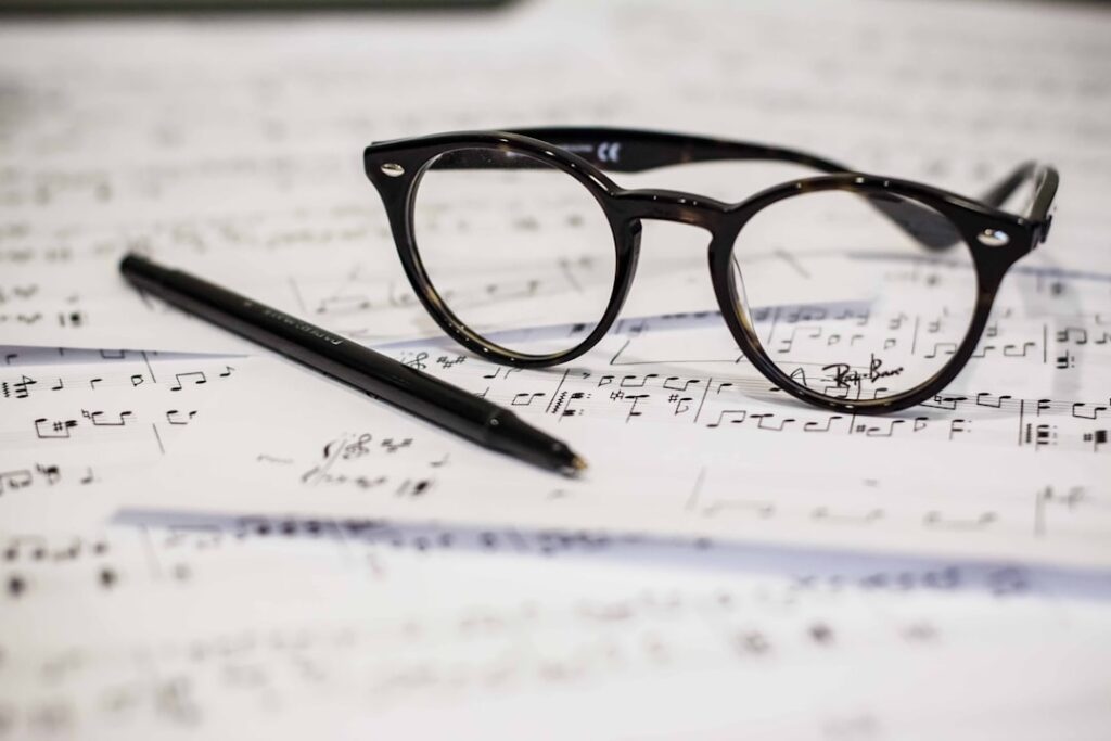 sheet music with glasses and pen.