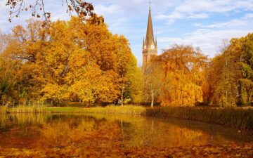 Autumn scenary in a park with a lake and a church