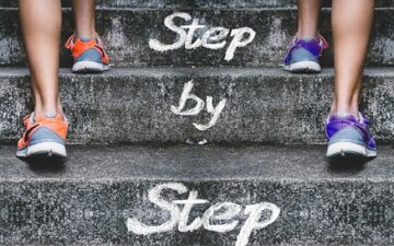 step by step logo with two feet walking.