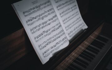 sheet music on a dark and black piano.